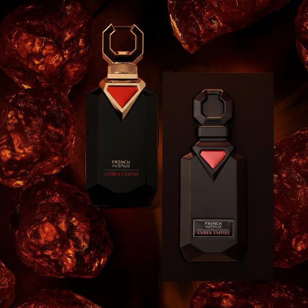 Two perfume bottles with a red triangle design on a dark background with amber stones.